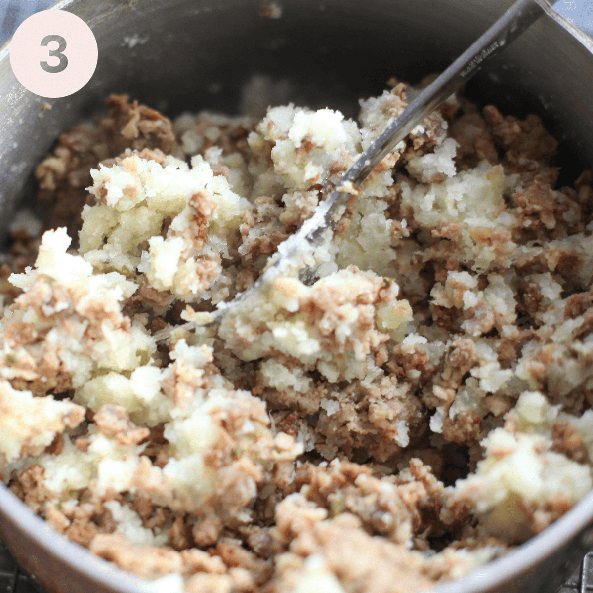 Stirring mashed potato into cold haggis.