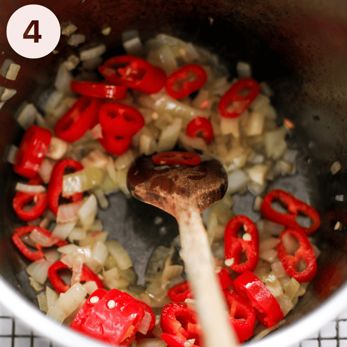 Adding chillis to aubergine chili.