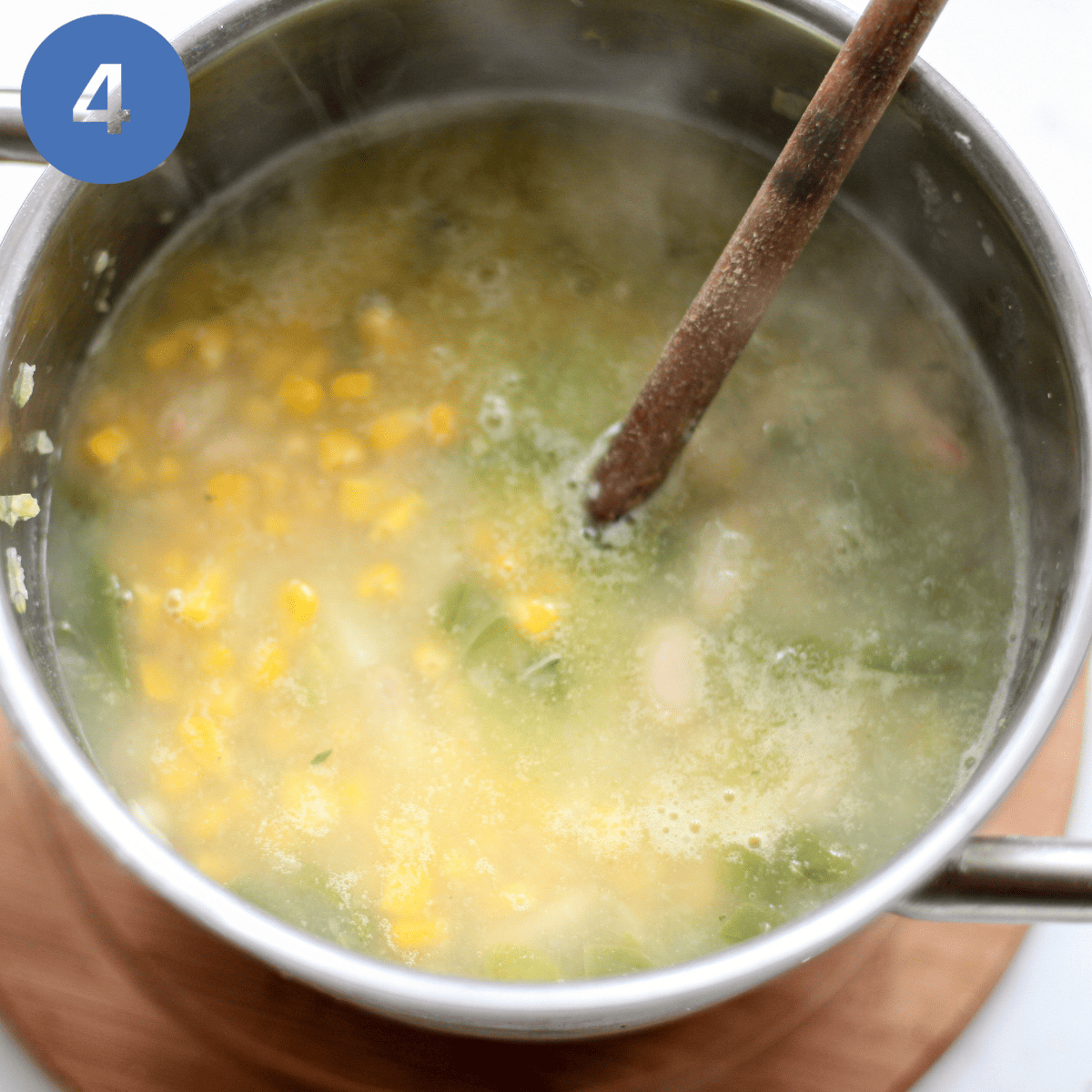 Adding the corn and beans to the chowder.