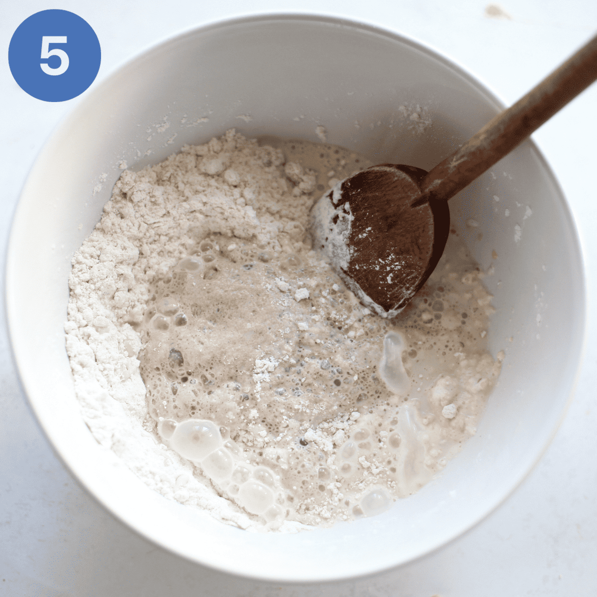 Adding yeast to sifted flour.