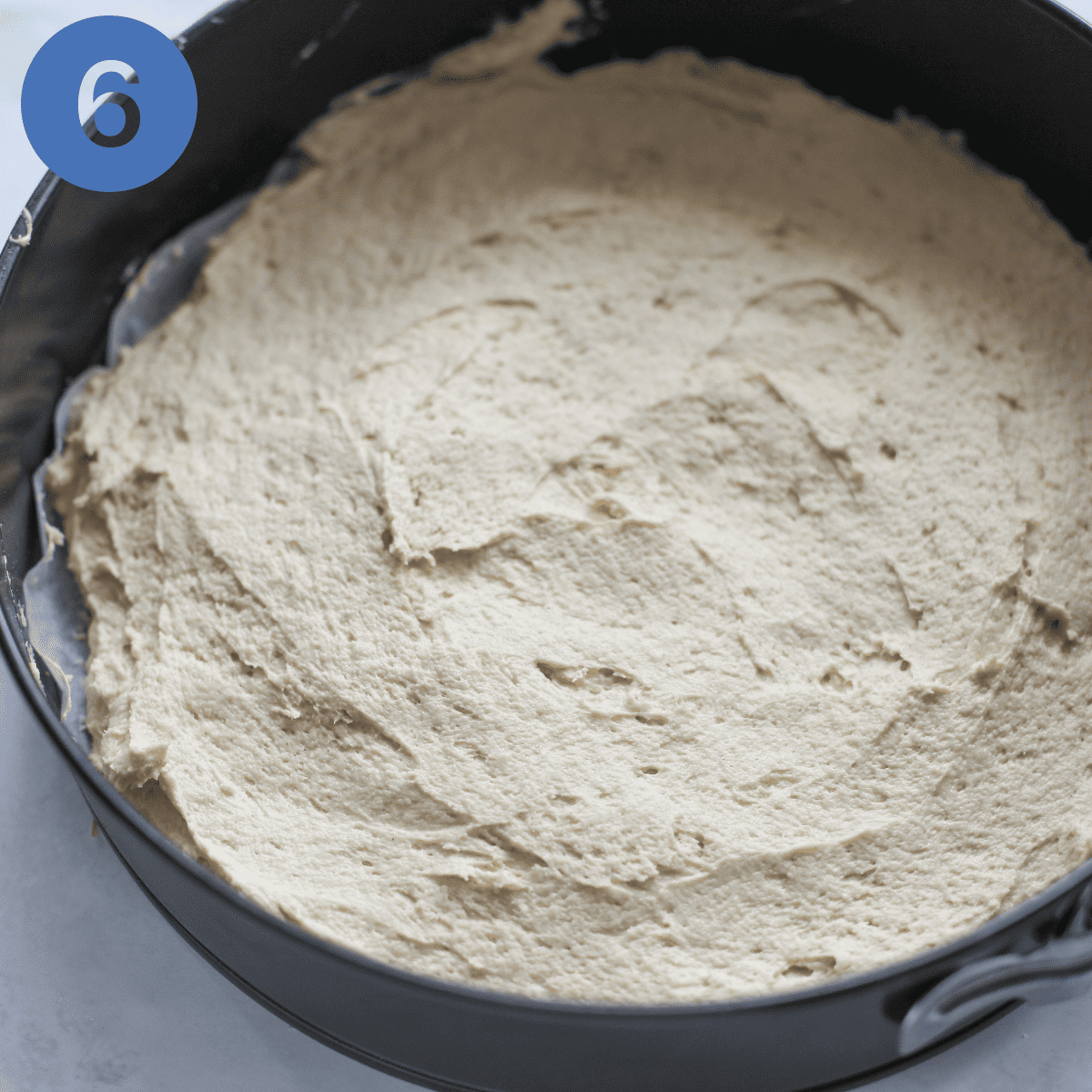 Putting cake batter into cake tin.