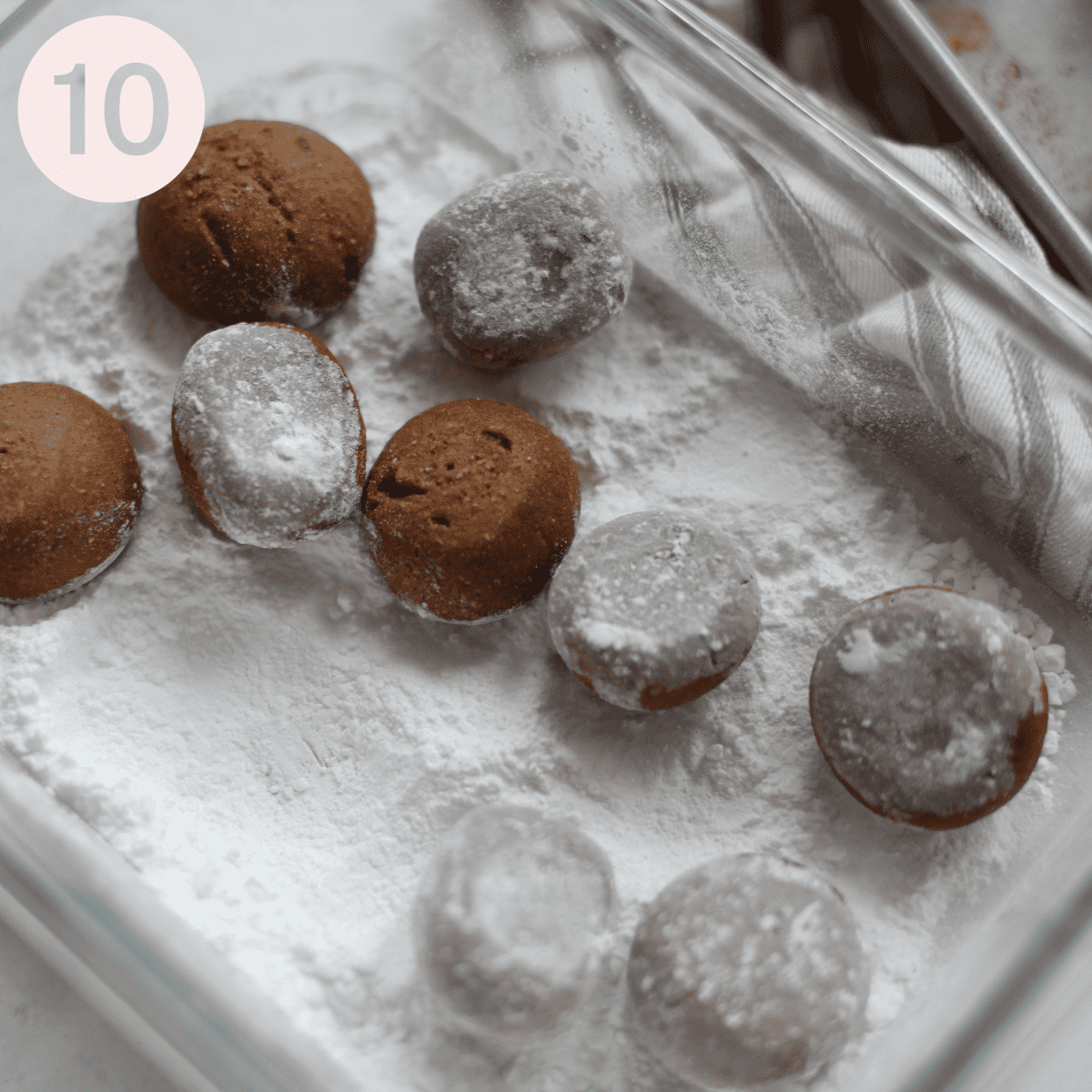 Tossing the baked pfeffernusse in icing sugar.