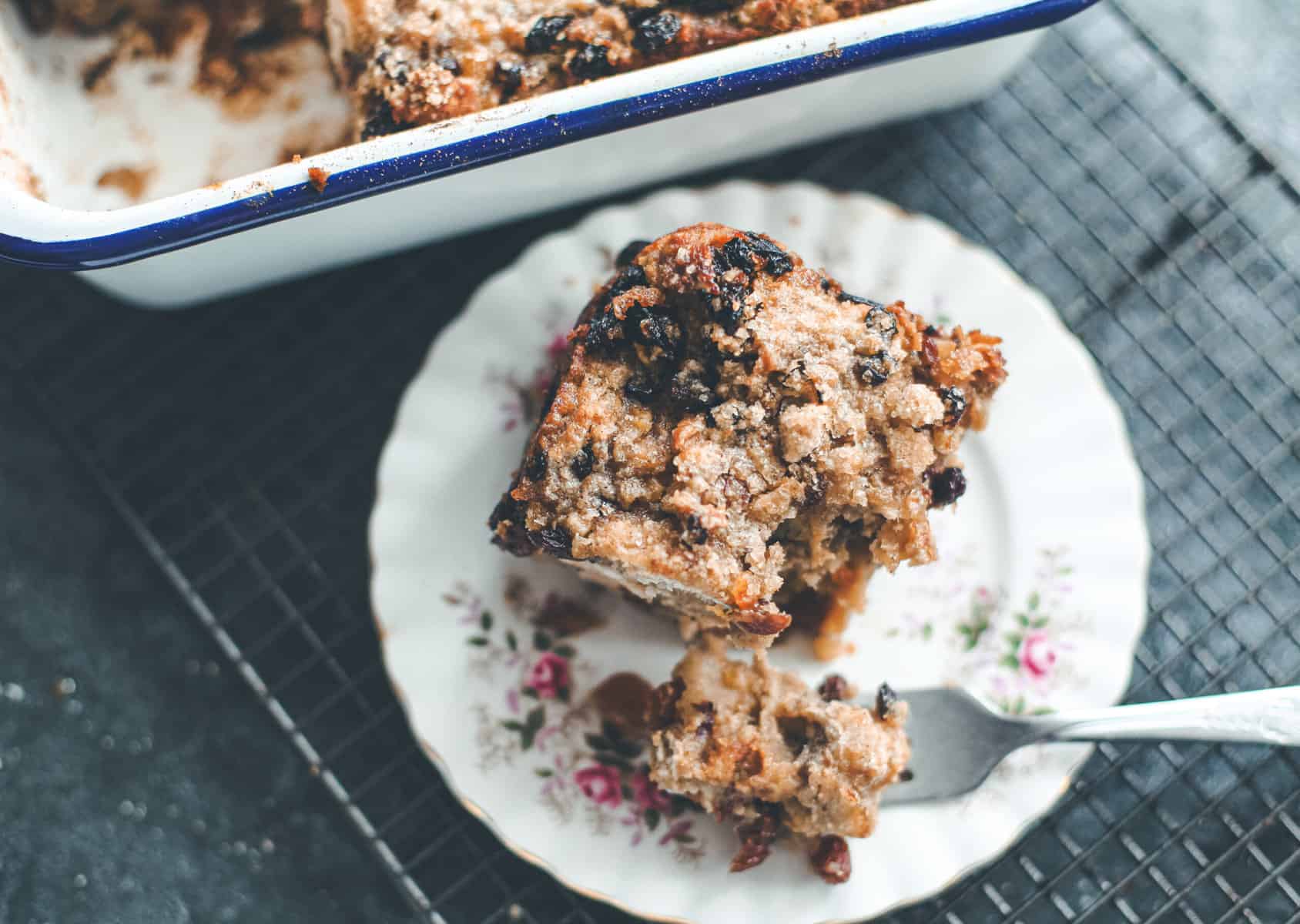 A slice of bread pudding on an intricate plate.