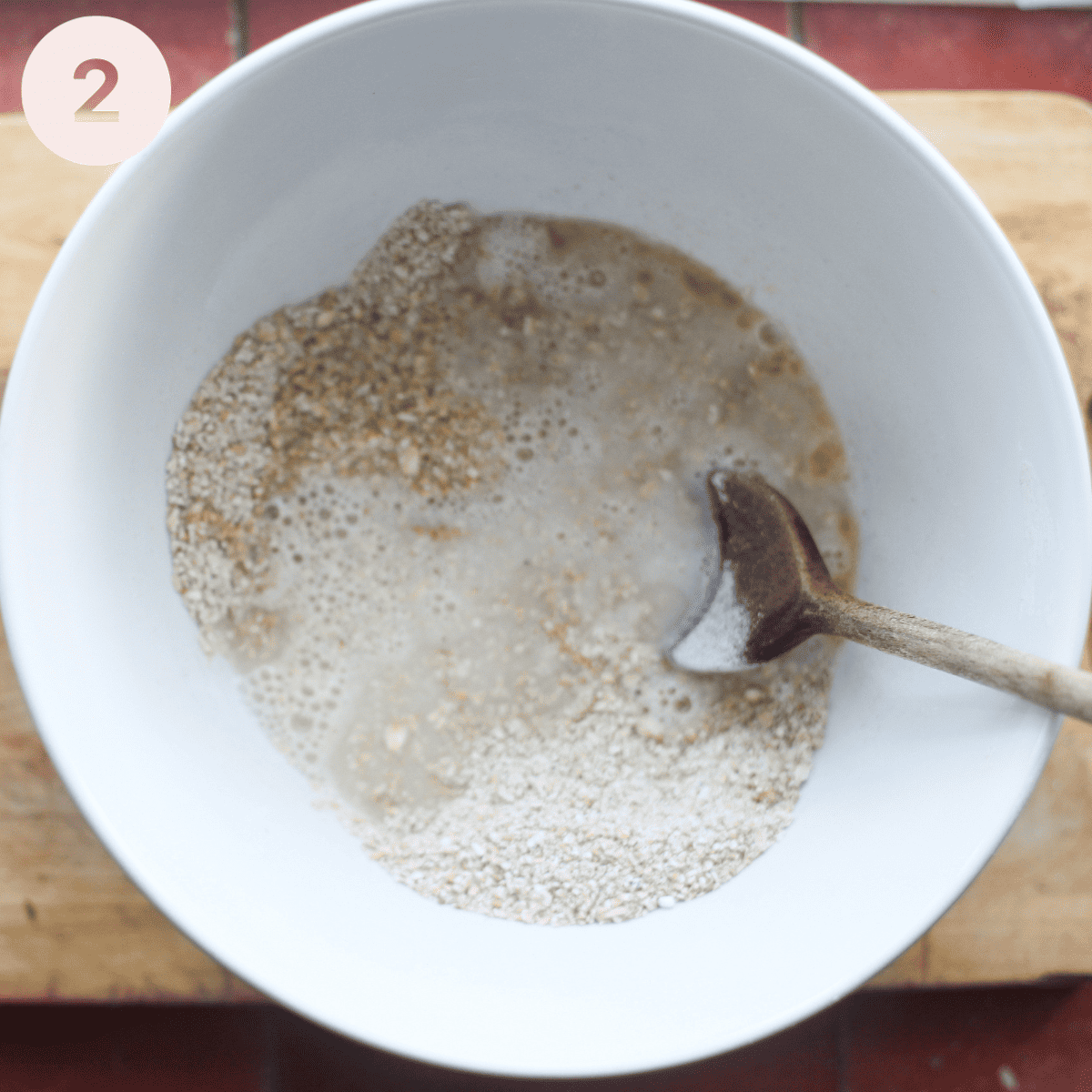 Adding water and melted butter to oats.
