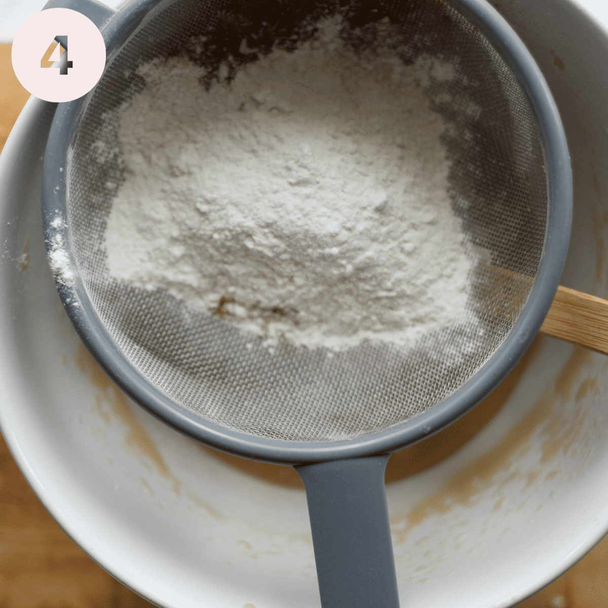 Sifting flour into the cake batter.